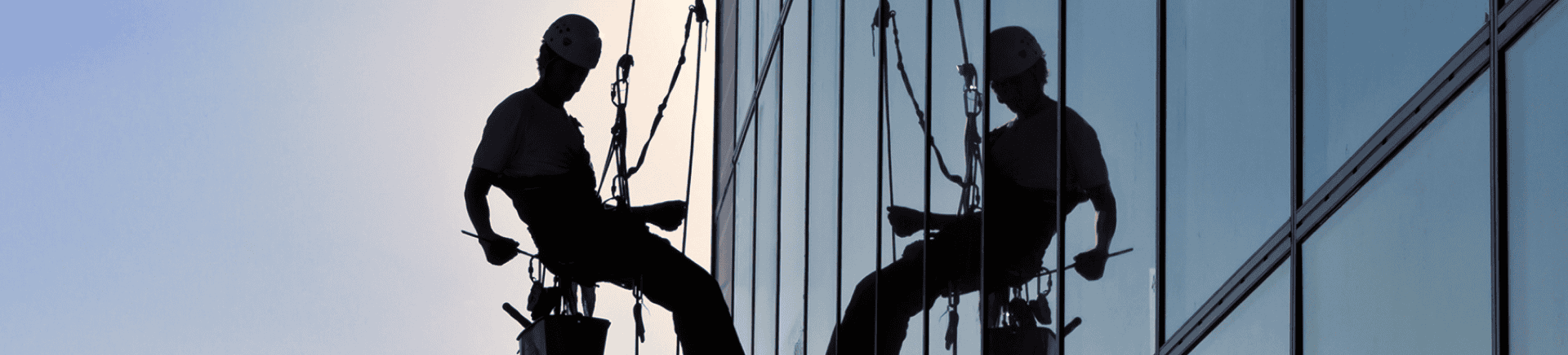 Shining and cleaning exterior glass windows of a commercial building with professional window cleaning services by Crown Glass. Skilled workers ensure spotless, streak-free glass surfaces.